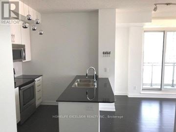 Mississauga (Creditview) condo for rent - A kitchen with a black counter top and white cabinets.