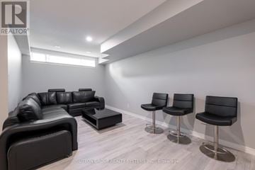 Oakville (Jc Joshua Creek) townhouse for rent - A modern living room with black leather furniture and a wooden floor.