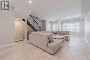 Oakville (Jc Joshua Creek) townhouse for rent - A spacious living room with a staircase and a couch.