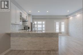 Oakville (Jc Joshua Creek) townhouse for rent - A kitchen with a stone counter top and wooden floors.