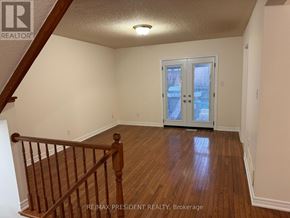 Hamilton (Stoney Creek) apartment for rent - A room with a wooden floor and a staircase leading to the upper floor.