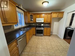 Hamilton (Stoney Creek) apartment for rent - A kitchen with wooden cabinets and a black countertop.