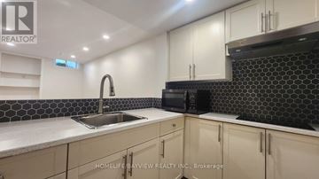 Richmond Hill (Oak Ridges) apartment for rent - A kitchen with a sink, microwave, and cabinets.