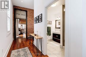 Hamilton (Beasley) apartment for rent - A hallway with a table and chairs in front of a brick wall.