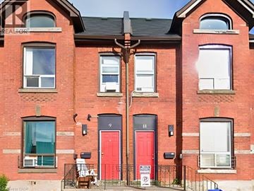 Hamilton apartment for rent - A red brick building with a red door and a sign that says "For Sale".