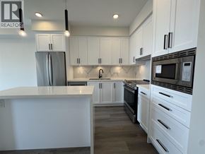 Maple Ridge apartment for rent - A modern kitchen with white cabinets and stainless steel appliances.