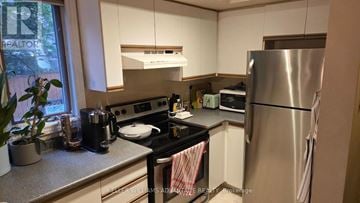 Toronto (Annex) condo for rent - A kitchen with a stove top oven and a refrigerator.