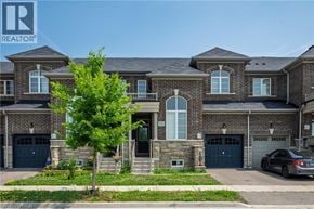 Milton townhouse for rent - A large, multi-story house with a stone facade and a garage.