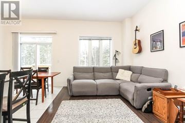 Wasaga Beach townhouse for rent - A living room with a grey couch and a wooden table.