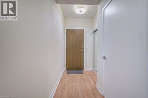 Mississauga condo for rent - A hallway with a wooden door and a light on the ceiling.