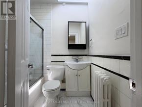 Toronto (Leaside) apartment for rent - A white bathroom with a toilet, sink, and mirror.