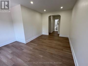 Toronto (Leaside) apartment for rent - A spacious room with wooden flooring and white walls.