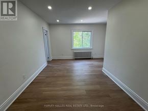 Toronto (Leaside) apartment for rent - A room with wooden flooring and a window with a view of trees outside.