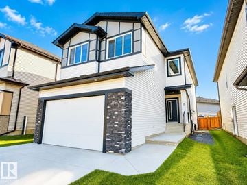 Leduc apartment for rent - A modern house with a white garage door and a stone pillar.