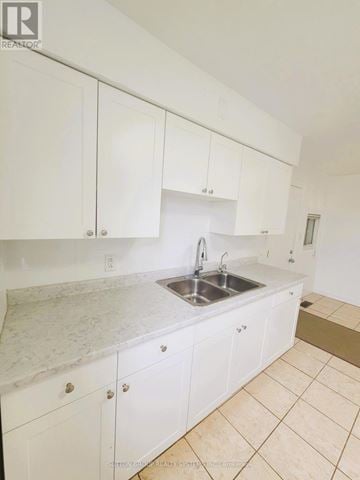 King apartment for rent - A kitchen with white cabinets and a marble countertop.