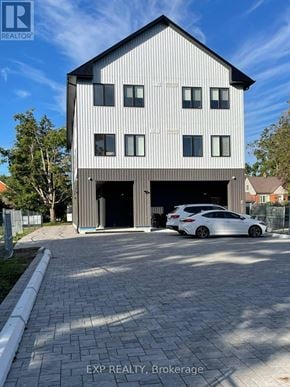 Barrie (Wellington) condo for rent - A modern house with a car parked in front.