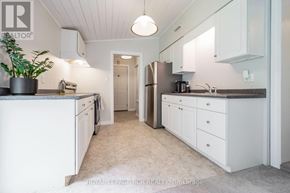 Orangeville apartment for rent - A kitchen with white cabinets and a grey floor.