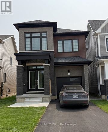 Brantford apartment for rent - A grey car is parked in front of a house with a sign that says "TEN REALTOR INC. Brokerage".
