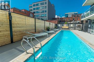 Ottawa condo for rent - A pool surrounded by a wooden fence and a metal railing.
