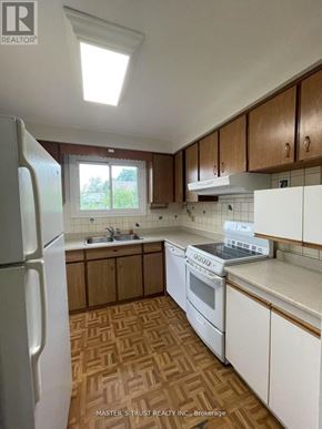 Toronto (West Hill) apartment for rent - A kitchen with wooden cabinets and a white fridge.