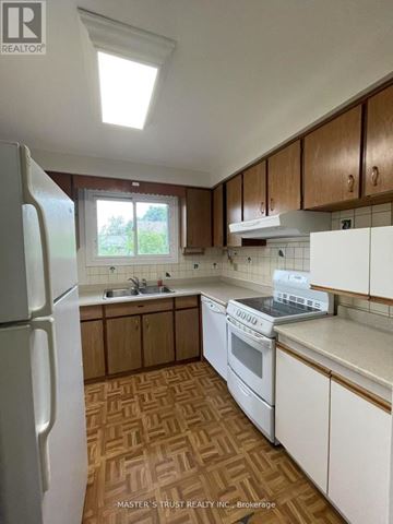 Toronto (West Hill) apartment for rent - A kitchen with wooden cabinets and a white fridge.