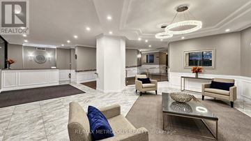 Mississauga (Applewood) condo for rent - A living room with a large couch, a coffee table, and a painting on the wall.