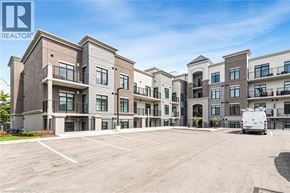 Ancaster condo for rent - A large, multi-story apartment complex with a parking lot in front.