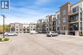 Ancaster condo for rent - A parking lot in front of a row of apartment buildings.