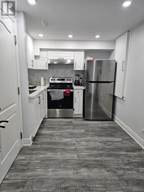 Brampton (Heart Lake East) apartment for rent - A kitchen with a stove, refrigerator, and cabinets.