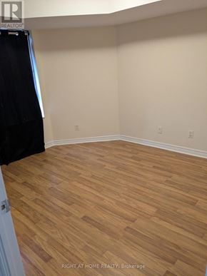 Mississauga (City Centre) condo for rent - A room with wooden flooring and a black curtain on the left side.