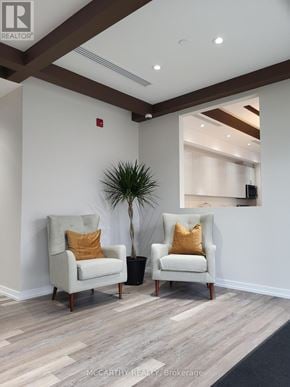 Southgate condo for rent - Two chairs with pillows are in the foreground of a room with a plant and a framed picture on the wall.