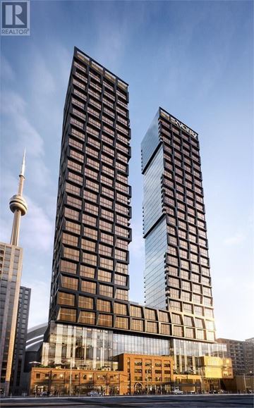 Toronto (Waterfront Communities) condo for rent - Two tall buildings with a glass facade stand next to a shorter building with a brown facade.
