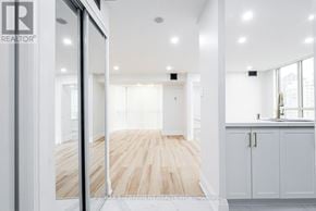 Mississauga (City Centre) condo for rent - A modern interior space with a wooden floor and white walls.