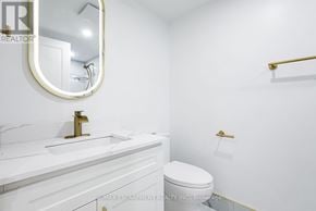 Mississauga (City Centre) condo for rent - A white bathroom with a toilet, sink, and mirror.