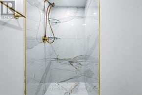 Mississauga (City Centre) condo for rent - A shower with a gold shower head and a gold rail.