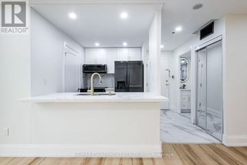 Mississauga (City Centre) condo for rent - A modern kitchen with white cabinets and a marble floor.