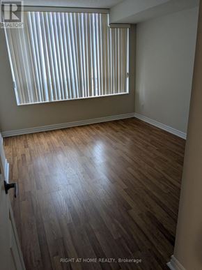 Mississauga (City Centre) condo for rent - A room with wooden flooring and a window with blinds.