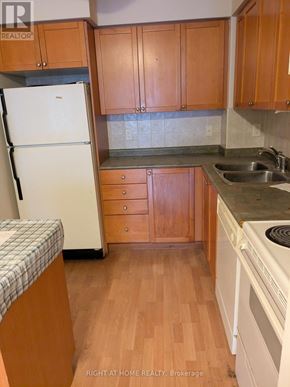 Mississauga (City Centre) condo for rent - A kitchen with wooden cabinets and a white refrigerator.