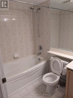 Mississauga (City Centre) condo for rent - A white toilet is in a bathroom with a tub and a shower.