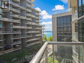 Toronto (Waterfront Communities) condo for rent - A view from a balcony of a building with a glass railing and a balcony on the floor below.