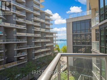 Toronto (Waterfront Communities) condo for rent - A view from a balcony of a building with a glass railing and a balcony on the floor below.