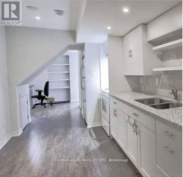 Richmond Hill (Langstaff) townhouse for rent - A spacious kitchen with white cabinets and a marble countertop.