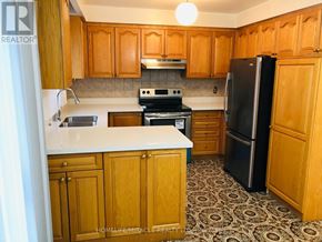 Toronto (Kingsview Village-The Westway) apartment for rent - A kitchen with wooden cabinets and a black refrigerator.