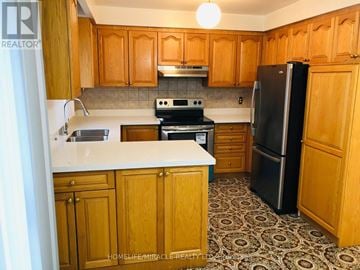 Toronto (Kingsview Village-The Westway) apartment for rent - A kitchen with wooden cabinets and a black refrigerator.