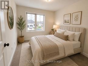 Smiths Falls townhouse for rent - A bedroom with a large bed and a window overlooking a street.