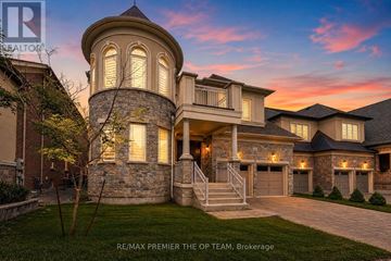 Vaughan (Kleinburg) apartment for rent - A large, beautiful house with a stone tower and a garage is shown.