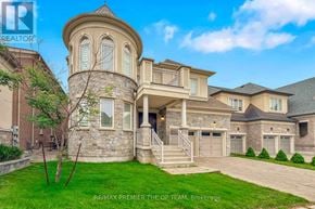 Vaughan (Kleinburg) apartment for rent - A large, luxurious house with a stone tower and a well-manicured lawn.