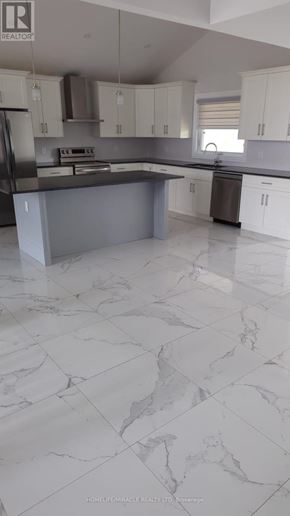 Amherstburg apartment for rent - A kitchen with a marble floor and white cabinets.