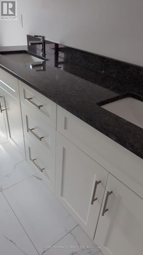 Amherstburg apartment for rent - A kitchen with white cabinets and a black counter top.