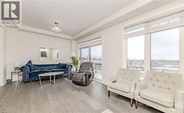 Stoney Creek apartment for rent - A living room with a blue couch and two white chairs.